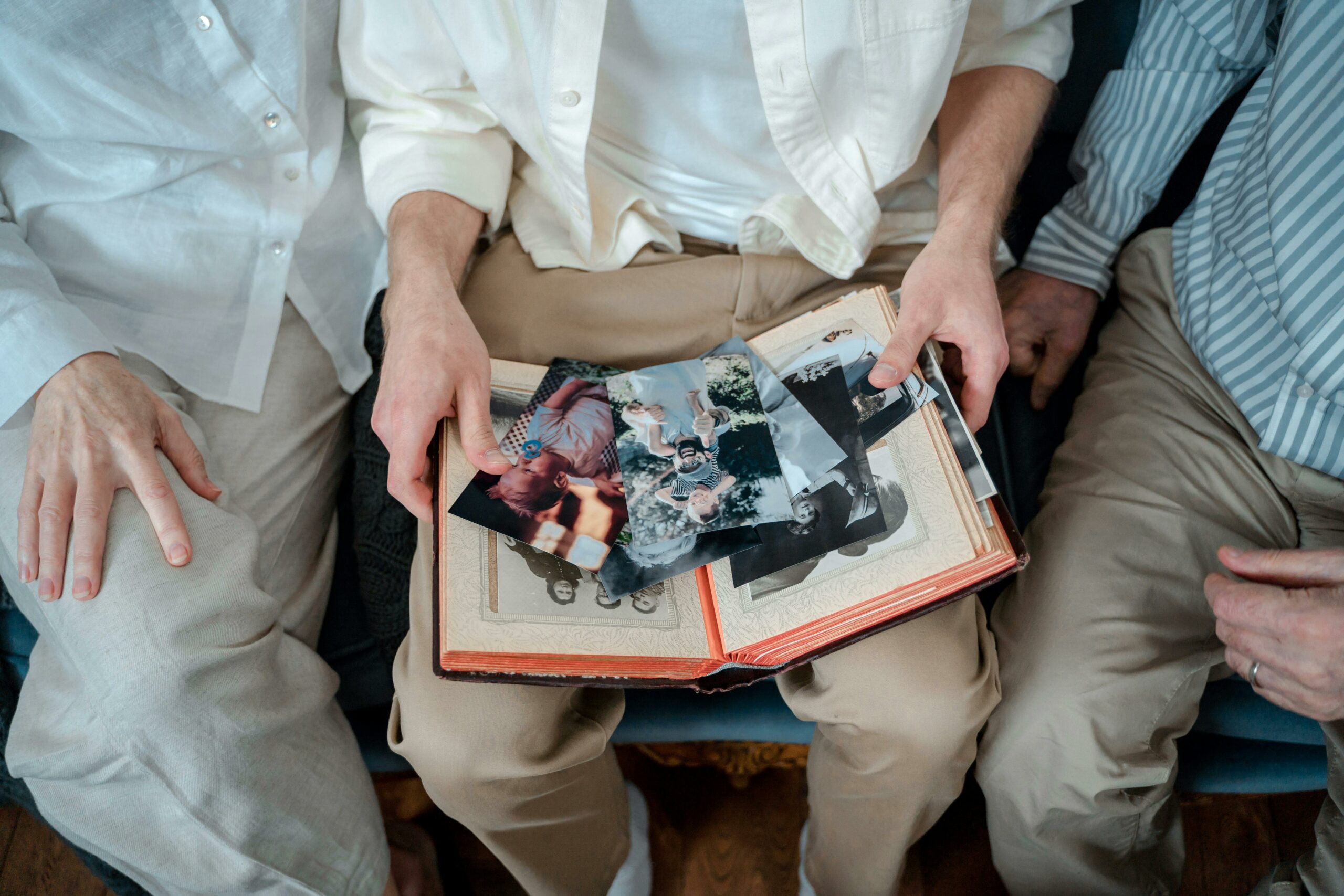 Accueil A family of three enjoying old photos together, sharing cherished memories.